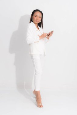 İş kadını için moda tarzı katalog kıyafetleri. Siyah uzun saç doğal makyaj. Beyaz takım elbise, mükemmel vücut şekli..