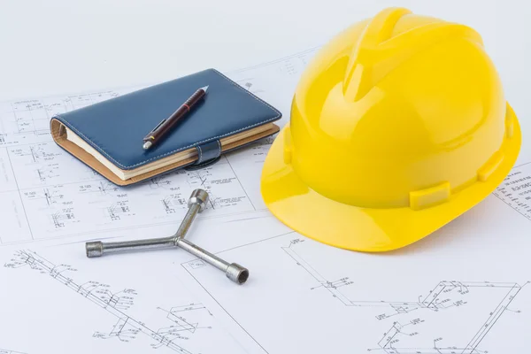 Sarı kask, somun anahtarı ve defter