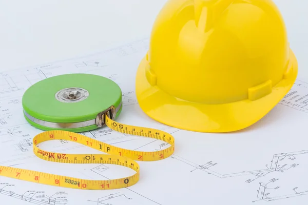 Casco de seguridad amarillo y cinta métrica verde — Foto de Stock