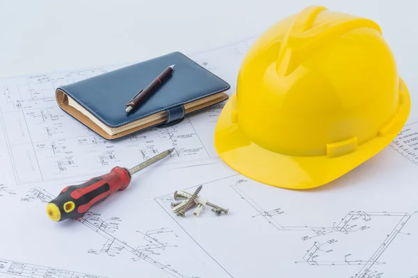 Yellow safety helmet, notebook and screwdriver Stock Photo