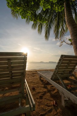 Kumsalda sandalyeler ve Koh Yao Noi, Tayland 'da gün doğumu gökyüzü.