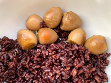 Yakın plan bıldırcın yumurtaları tatlı yahni (Kai Palo) içinde Riceberry pilavı, ev yemeği, Tayland yemeği.