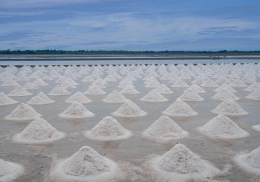 Deniz tuzu piramitleri mavi gökyüzü, deniz tuzu yığınları, geleneksel tuz tarımındaki doğal materyal, tuz tarlalarındaki tuz tarlalarında hasat için hazırdır. Tayland 'da sanayi, Asya kültürü
