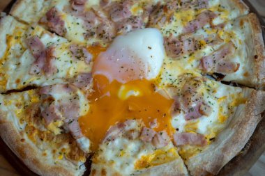 Tahta tepside haşlanmış yumurtalı Carbonara pizzası, ev yapımı İtalyan yemeği.