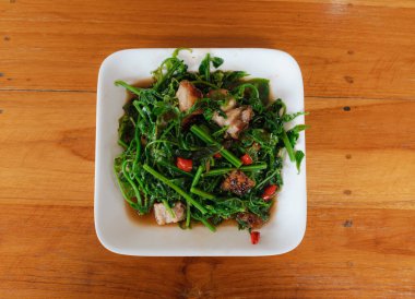 Kızarmış eğreltiotu soslu sebze, ahşap masada kızarmış domuz eti, Tayland yemeği.