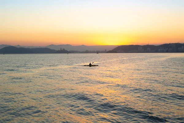 Silhouet Van Een Eenzame Kanoër Peddelend Santos Bay Tijdens Zonsondergang — Stockfoto