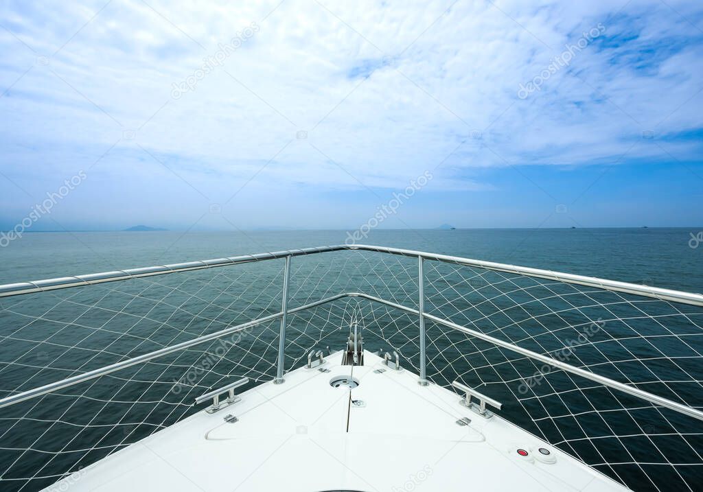 View from the bow of a 27-foot speedboat sailing along the coast with the horizon in the background.