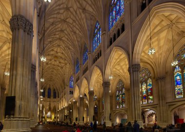New York, ABD. 08 Nisan 2016. Manhattan 'daki Aziz Patrick Katedrali' nin iç manzarası Gotik kemerler, vitraylı pencereler ve sıralarda oturan ziyaretçiler..