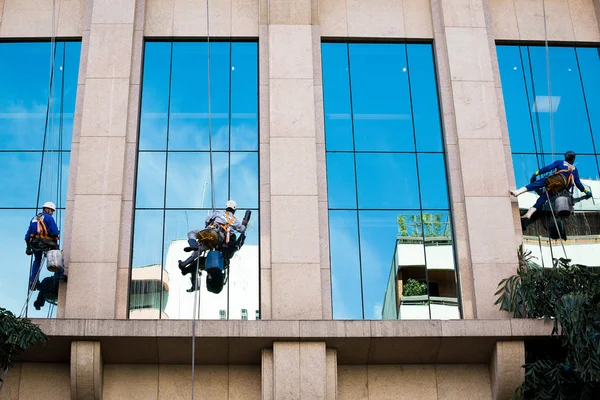 Três trabalhadores limpando janelas — Fotografia de Stock