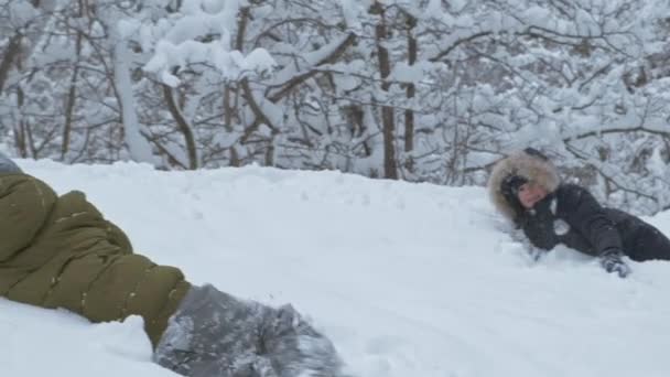 Хлопчики розважаються зі снігом в зимовому парку у відпустці — стокове відео