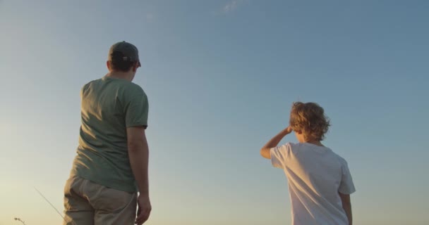 Happy child holding fathers hand walking outdoors — Stock Video