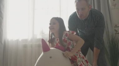 Gülümseyen baba evde tatlı çocukla eğleniyor.