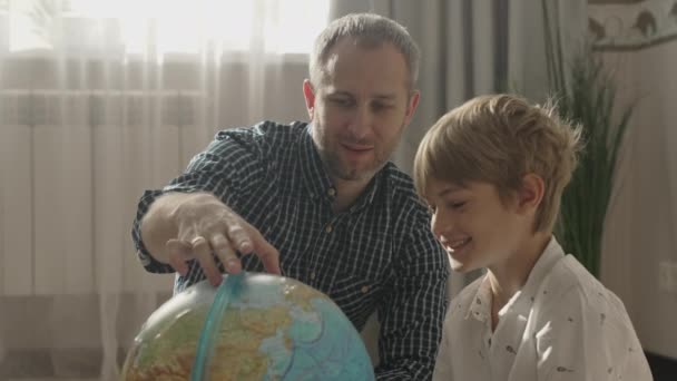 Happy dad and small kid boy looking at globe, — Stock Video