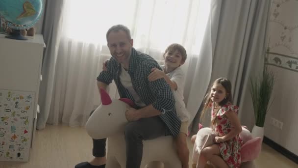 Улыбающийся отец веселится с милыми детьми дома — стоковое видео