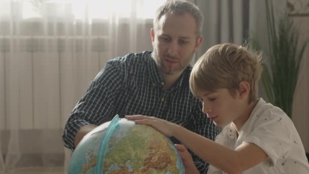 Gelukkige vader en kleine jongen op zoek naar wereldbol, — Stockvideo