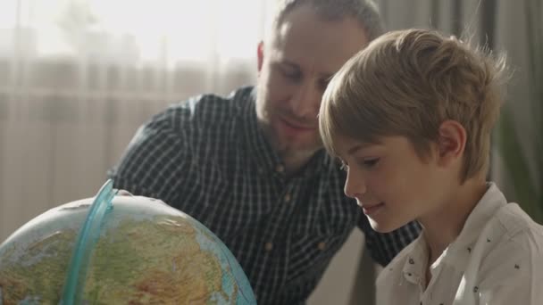 Šťastný táta a malý chlapec při pohledu na zeměkouli, — Stock video