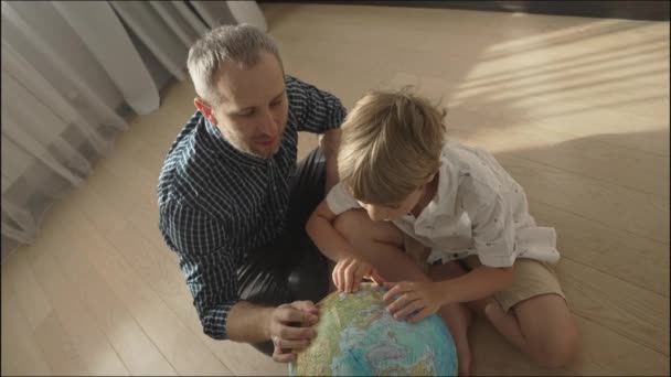 Šťastný táta a malý chlapec při pohledu na zeměkouli, — Stock video