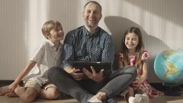 Rodzina ogląda zabawny film przez tablet. — Wideo stockowe