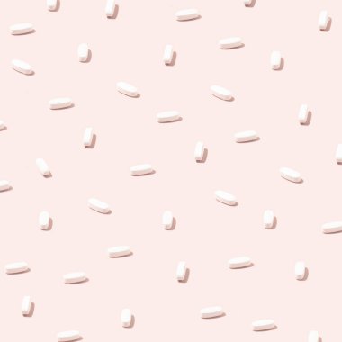 Pastel pembe arka planda bulunan beyaz ilaç tabletlerinden oluşan yaratıcı desen. Covid farkındalığı veya bağışıklık sistemi sağlık fotoğrafı.