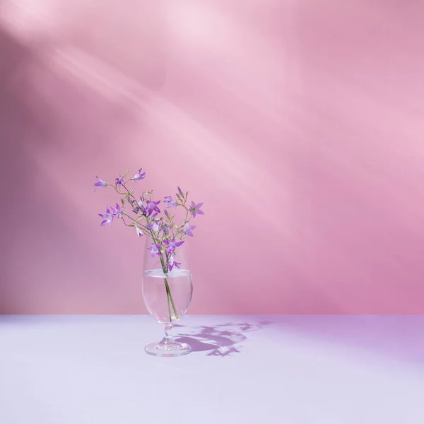 Kaca Dengan Cairan Transparan Dan Indah Bunga Bunga Bidang Ungu — Stok Foto