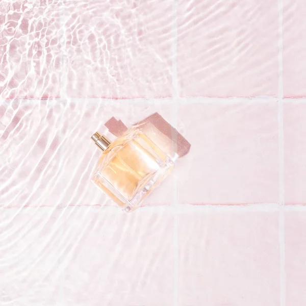Parfum Golder Dalam Air Dengan Gelombang Kecil Latar Belakang Pastel — Stok Foto