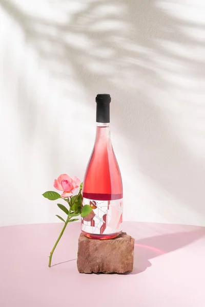 Botella Vino Rosa Sobre Piedra Roja Una Rosa Rosa Contra — Foto de Stock