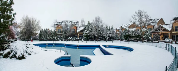 Snow-covered yard with a pool in a beautiful neighborhood in Bucharest. Christmas background. Cold temperature, wintertime