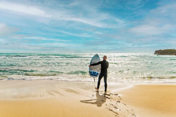 Water sports, surfing, surf board, Agia Napa, Cyprus.A surfer getting into the water