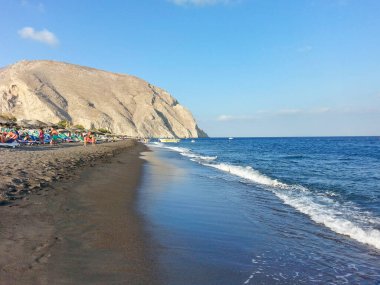 Perissa, Yunan adası Santorini 'nin en ünlü plajı. Güneşli güzel bir gün, kristal su. Sakin bir bar.