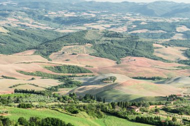 Volterra manzarası, yuvarlanan tepeler ve gün batımında yeşil alanlar.