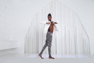 Sahne kıyafetleri içinde siyah bir adam dans ediyor..