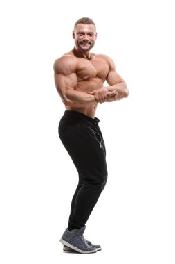 Çıplak gövdeli genç atletik bir adam beyaz bir arka planda tamamen yalıtılmış bir şekilde duruyor..