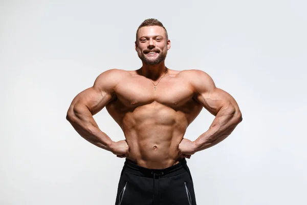 Jonge Gespierde Bodybuilder Kerel Demonstreert Zijn Spieren Geïsoleerd Een Licht — Stockfoto