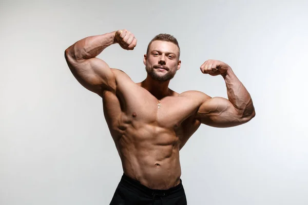 Jovem Musculoso Cara Musculoso Demonstra Seus Músculos Isolados Fundo Cinza — Fotografia de Stock