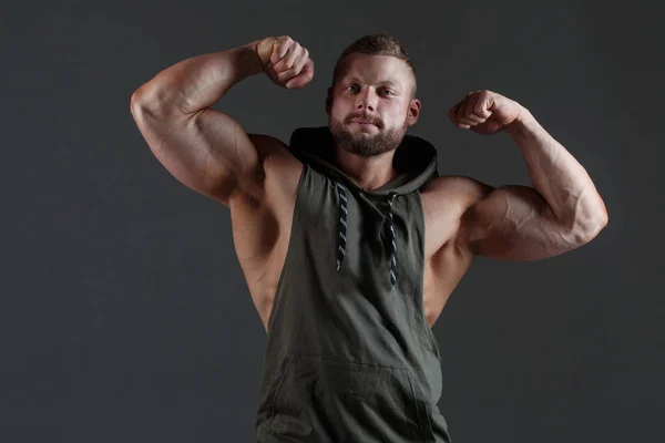 Muskulöser Weißer Mann Zeigt Bizeps Vor Dunklem Hintergrund — Stockfoto