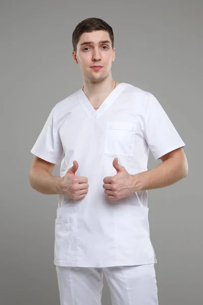 Fiatal Férfi Orvosi Overálban Egy Felemelt Hüvelykujjat Mutat Mindkét Kezén — Stock Fotó