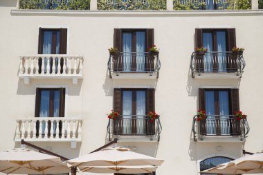 Balkonları ve pencereleri açık pencereleri olan bir Akdeniz evi duvarı..