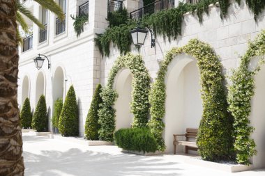 Karadağ 'ın Tivat caddesinde dinlenmek için bankları olan gölgeli kemerler.