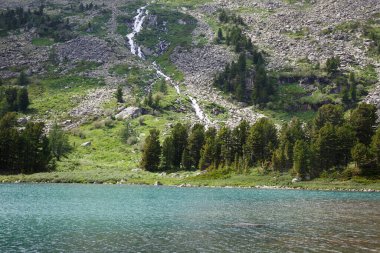 Tepe yamacında bir şelale, Altai 'de bir dağ gölü yakınında..