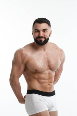 Beyaz arka planda çıplak gövdesi olan atletik sakallı bir adam..