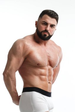 Beyaz arka planda çıplak gövdesi olan atletik sakallı bir adam..