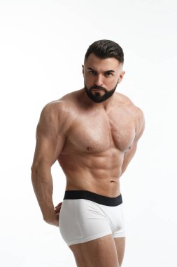 Beyaz arka planda çıplak gövdesi olan atletik sakallı bir adam..