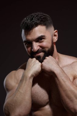 Siyah arka planda izole edilmiş atletik sakallı çekici adamın portresi..