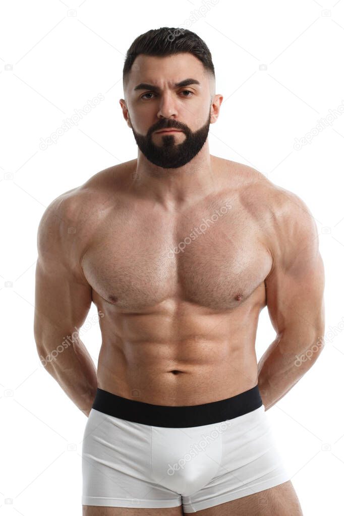 Athletic bearded man with bared muscular torso with his arms folded behind his back, isolated on white background.