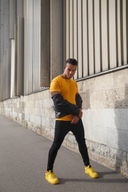 Şehir caddesinde dans eden genç ve çekici Latin adam..