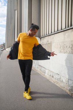 Şehir caddesinde dans eden genç ve çekici Latin adam..