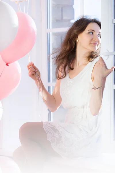 Menina bonito sentado em uma janela — Fotografia de Stock