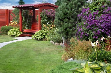 Bahçe bir tezgah, çim ve çiçek görev ile rahat bir köşesinde