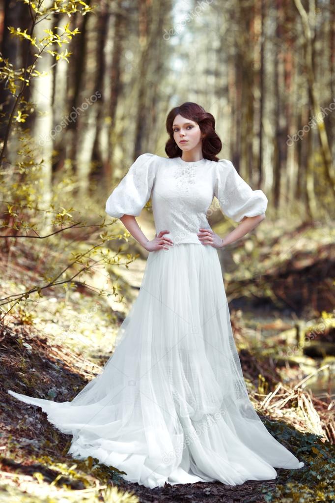 Beautiful girl in a white dress in the forest — Stock Photo