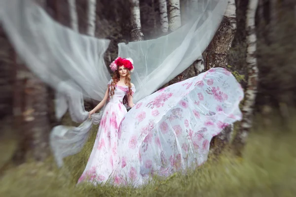 Mulheres em desenvolver o vento vestido longo em uma floresta misteriosa — Fotografia de Stock